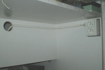Fotografie dvojzásuvky připevněné na pravé bočnici pod deskou stolu.